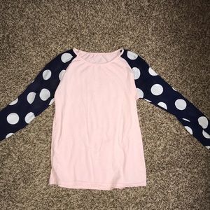 Pink shirt with navy and white polka dot sleeves